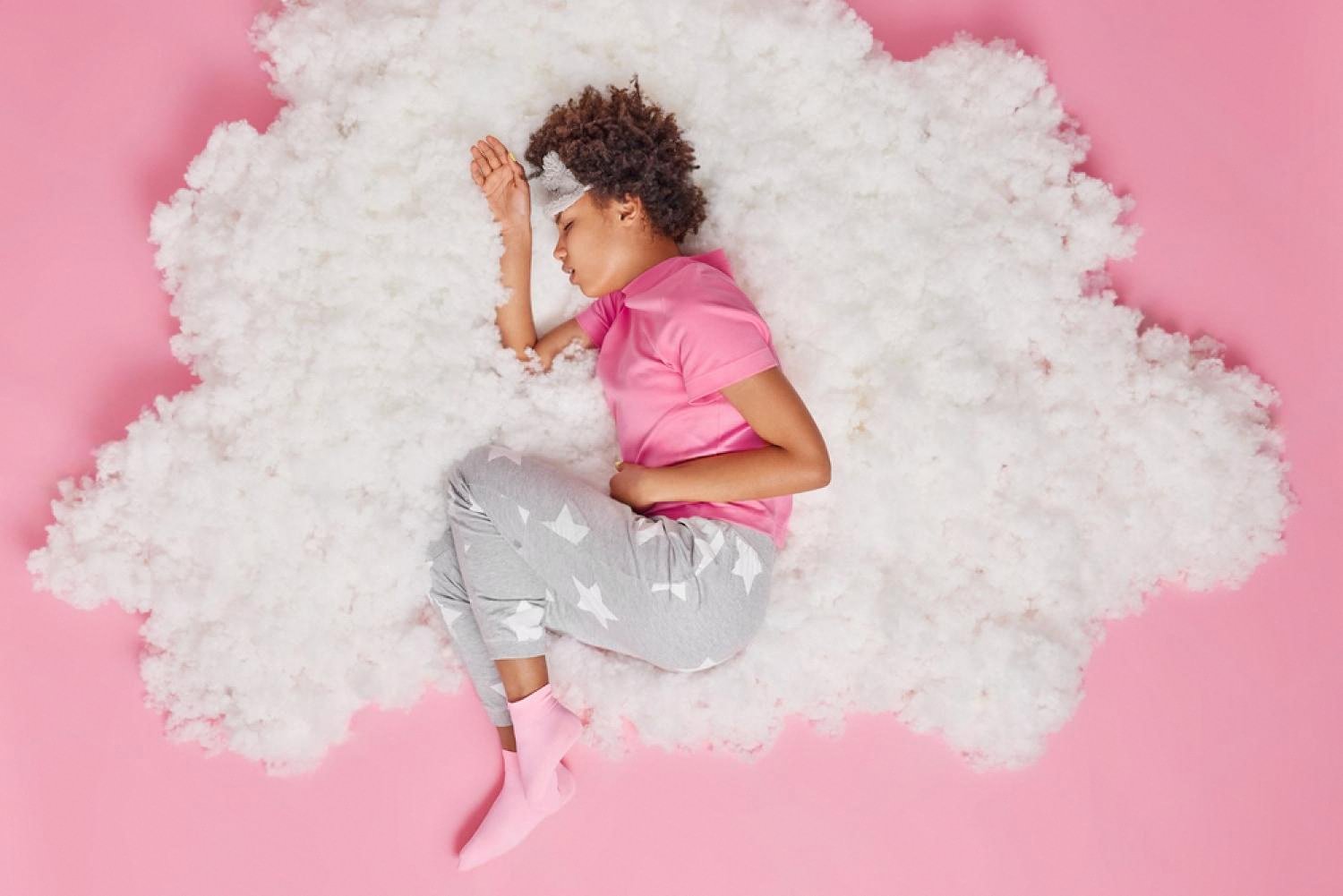 Woman curled up in discomfort at night, illustrating how IBS and IBD disturb sleep